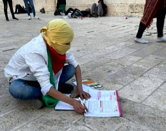 نوجوان فلسطینی در حال نوشتن مشق هایش در صحن مسجدالاقصی/ عکس
